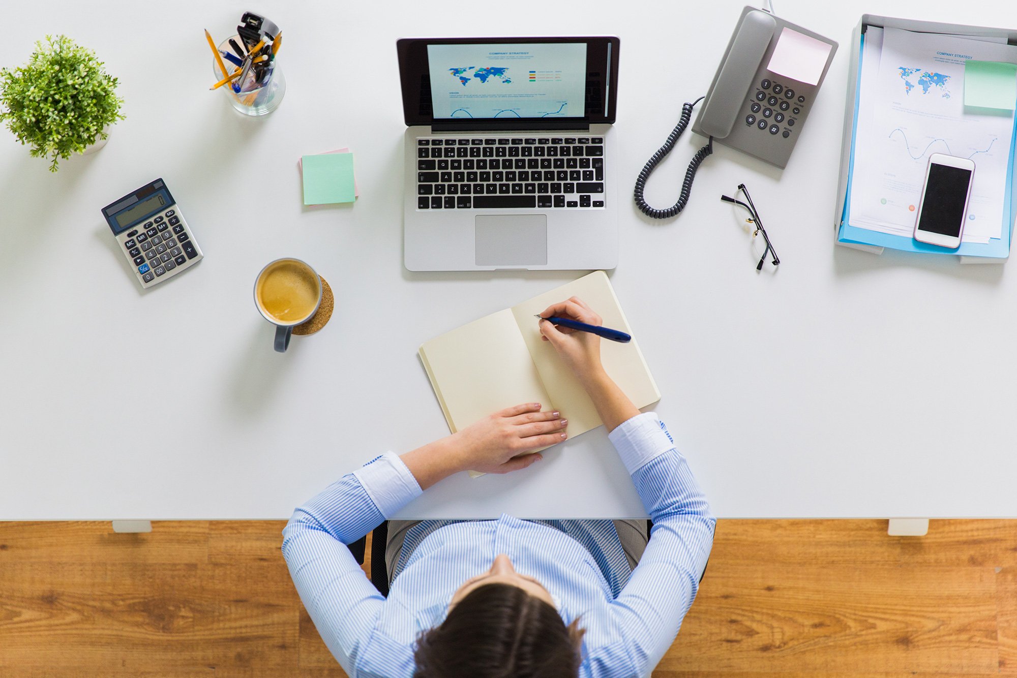 businesswoman-writing-to-notebook-at-office-web